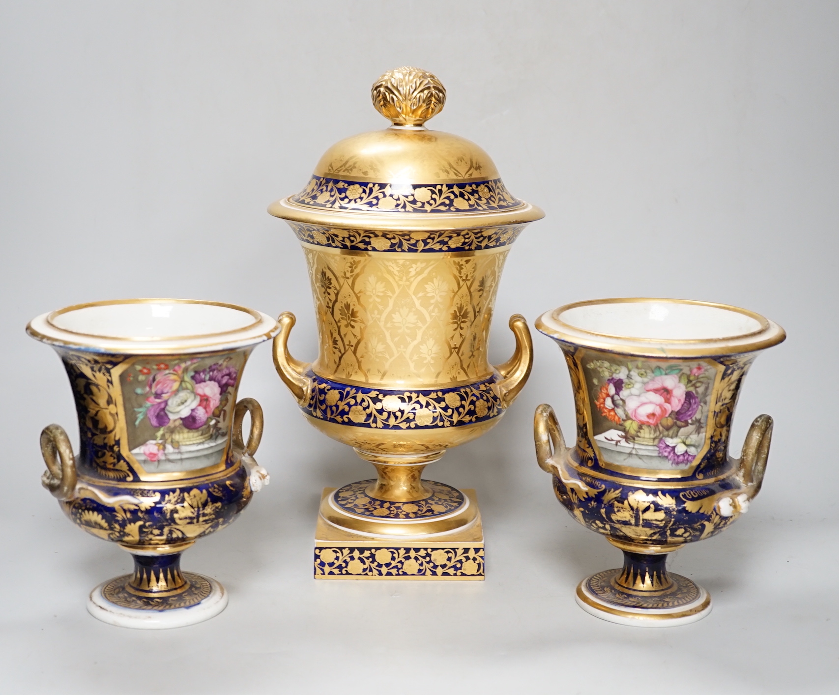 A pair of Derby flower basket painted urns, c.1810, and a larger Derby urn and cover, first quarter 19th century, latter 30cm